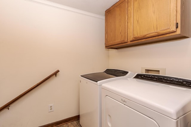 laundry area with baseboards, washer and clothes dryer, ornamental molding, and cabinet space