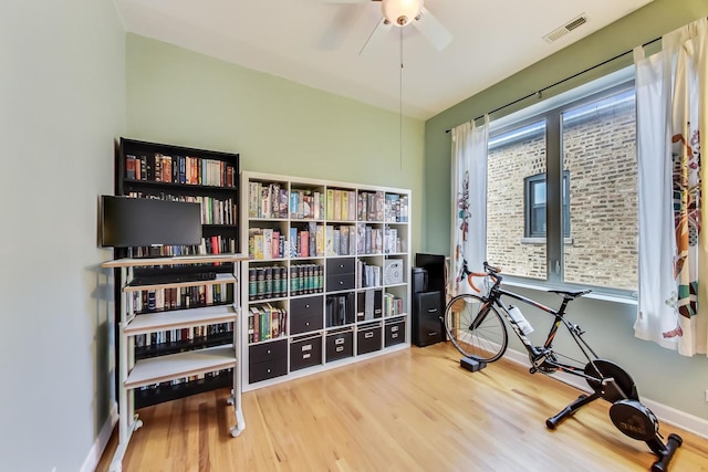 workout area with wood finished floors, baseboards, ceiling fan, and visible vents