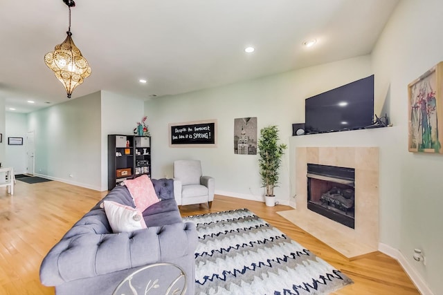 living area with baseboards, wood finished floors, and recessed lighting