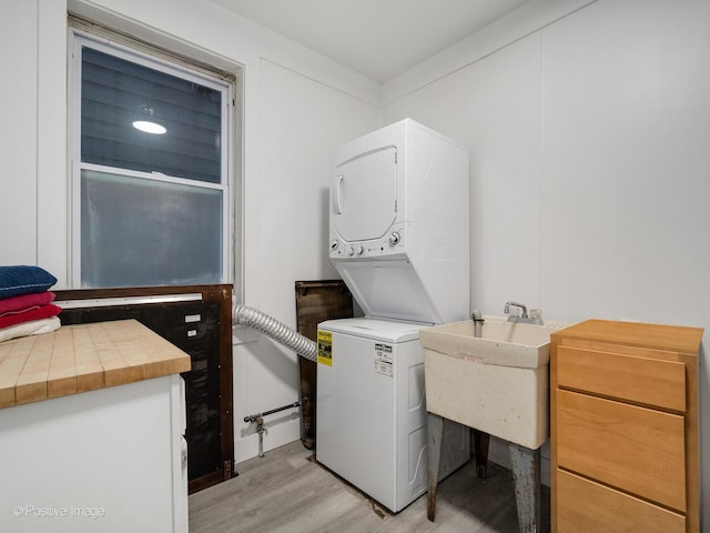 1812 W Erie St, Chicago, IL 60622 - washroom with light wood finished floors, laundry area, stacked washer and clothes dryer, and a sink