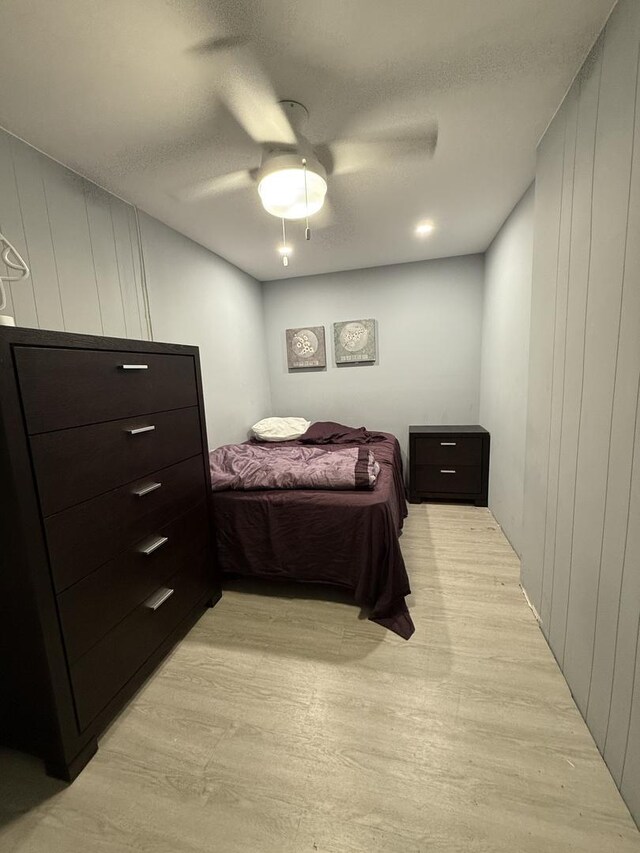 1812 W Erie St, Chicago, IL 60622 - bedroom featuring wooden walls, light wood-type flooring, a textured ceiling, and a ceiling fan