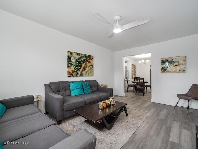 1812 W Erie St, Chicago, IL 60622 - living room featuring ceiling fan with notable chandelier, baseboards, and wood finished floors