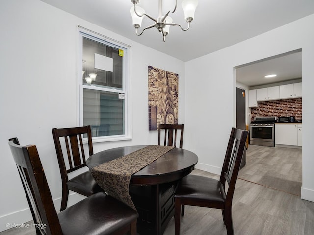 1812 W Erie St, Chicago, IL 60622 - dining space with baseboards, light wood finished floors, and an inviting chandelier