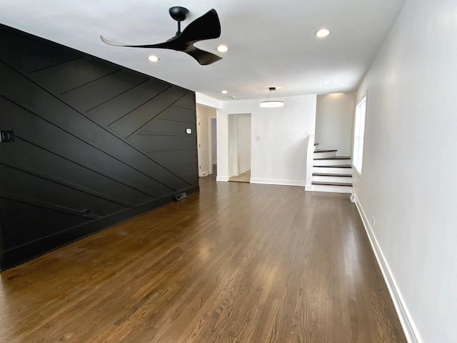 unfurnished living room featuring a ceiling fan, dark wood-style flooring, recessed lighting, baseboards, and stairs