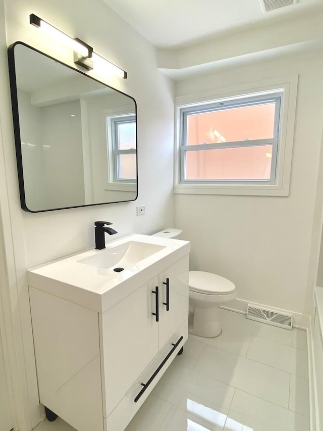 bathroom featuring visible vents, baseboards, toilet, and vanity