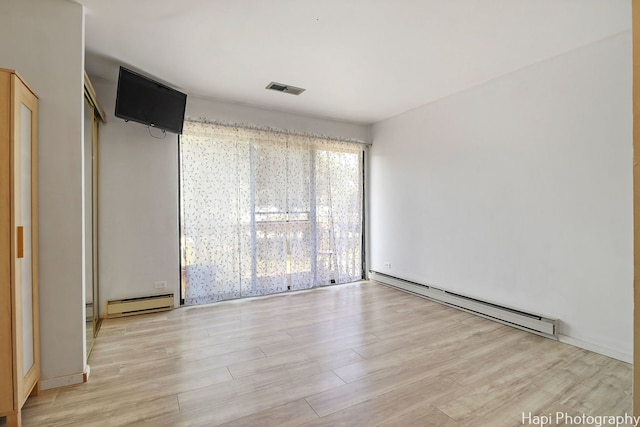 41 Bermuda Colony Unit 5, Fox Lake, IL 60020 - unfurnished bedroom with baseboard heating, a baseboard radiator, and light wood-style floors