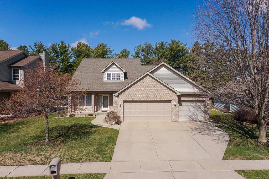 1008 Pine Meadows Ct, Normal, IL 61761 - view of front of property featuring concrete driveway, a garage, a front lawn, brick siding, and a shingled roof