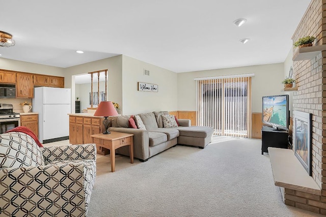 18148 Vermont Ct Unit 243, Orland Park, IL 60467 - living area featuring light colored carpet, a brick fireplace, and a wainscoted wall