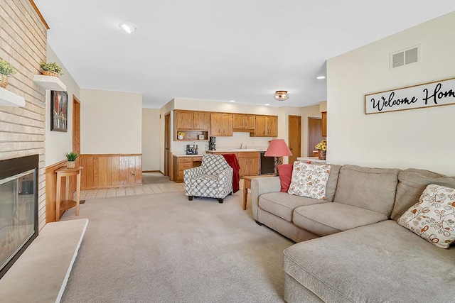18148 Vermont Ct Unit 243, Orland Park, IL 60467 - living area with light carpet, a wainscoted wall, wooden walls, a fireplace, and recessed lighting