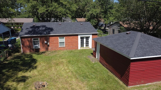 back of property featuring a yard, cooling unit, and roof with shingles