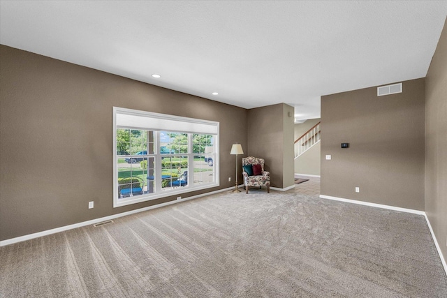 1310 Kimela Dr, Mahomet, IL 61853 - unfurnished living room featuring stairs, baseboards, carpet floors, and recessed lighting