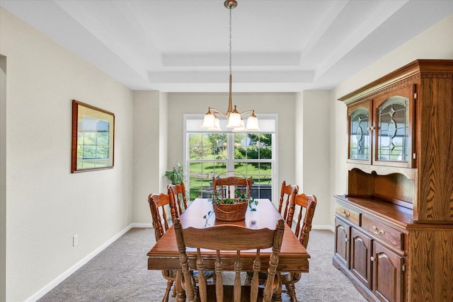 1310 Kimela Dr, Mahomet, IL 61853 - dining area with a tray ceiling, light colored carpet, a chandelier, and baseboards