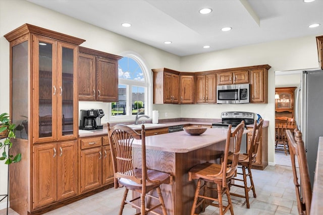 1310 Kimela Dr, Mahomet, IL 61853 - kitchen with stainless steel appliances, recessed lighting, a sink, light countertops, and a kitchen island