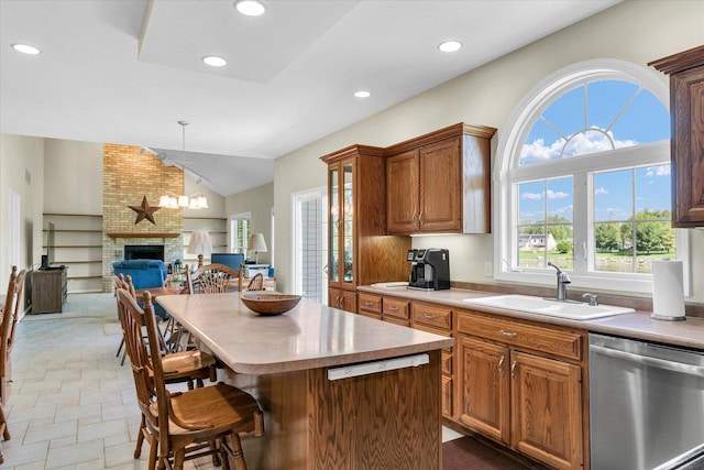 1310 Kimela Dr, Mahomet, IL 61853 - kitchen featuring dishwasher, a sink, lofted ceiling, a brick fireplace, and recessed lighting