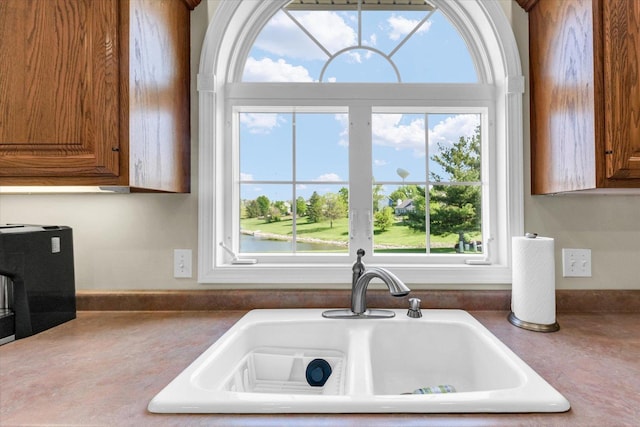 1310 Kimela Dr, Mahomet, IL 61853 - kitchen featuring a sink, brown cabinets, and dark countertops