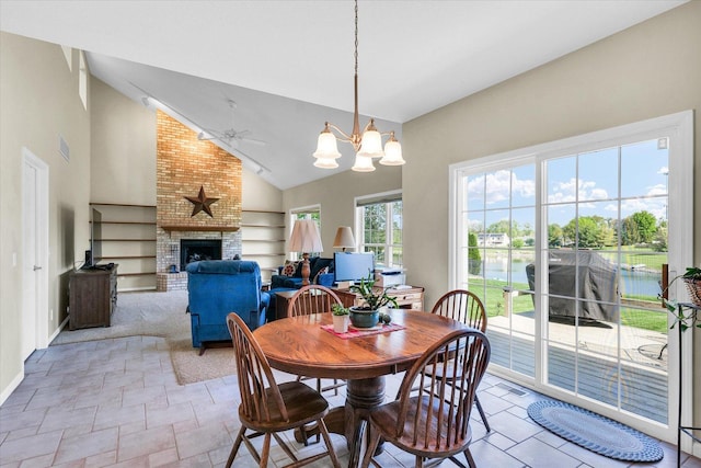 1310 Kimela Dr, Mahomet, IL 61853 - dining area featuring a ceiling fan, a chandelier, a fireplace, baseboards, and high vaulted ceiling