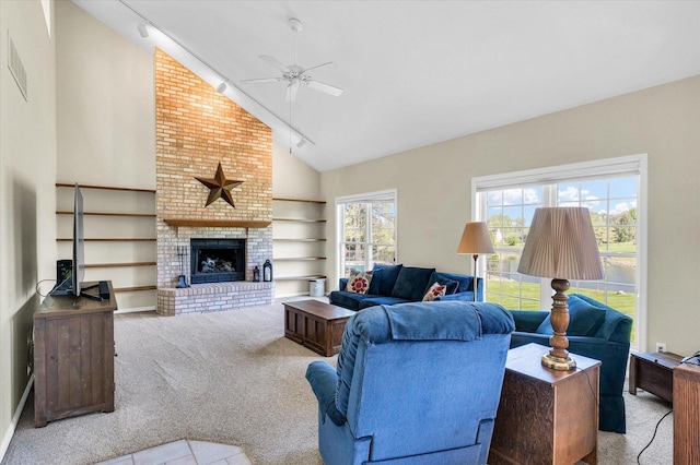 1310 Kimela Dr, Mahomet, IL 61853 - living room featuring carpet floors, a ceiling fan, high vaulted ceiling, a brick fireplace, and track lighting