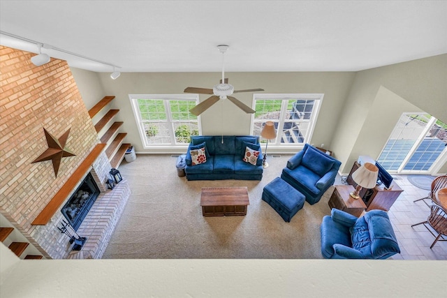1310 Kimela Dr, Mahomet, IL 61853 - living area featuring rail lighting, a fireplace, ceiling fan, and baseboards
