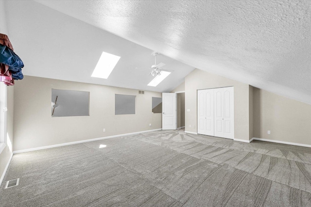 1310 Kimela Dr, Mahomet, IL 61853 - additional living space with a skylight, lofted ceiling, carpet floors, a ceiling fan, and baseboards