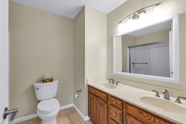 1310 Kimela Dr, Mahomet, IL 61853 - bathroom with toilet, tile patterned floors, double vanity, baseboards, and a shower with shower door
