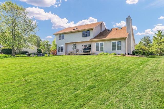 1310 Kimela Dr, Mahomet, IL 61853 - back of property featuring a chimney, a yard, and a deck