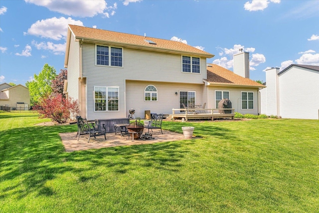 1310 Kimela Dr, Mahomet, IL 61853 - back of property with a patio area, a yard, a chimney, and a deck