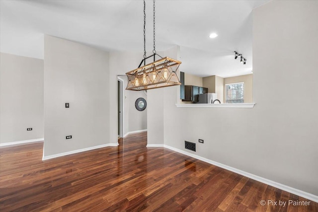 unfurnished dining area featuring visible vents, baseboards, and wood finished floors