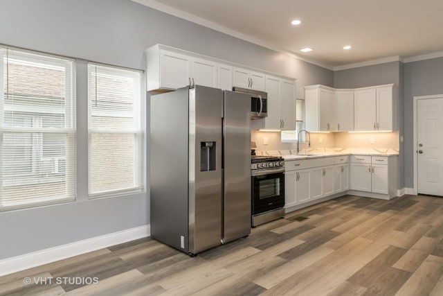 2017 W 68th St, Chicago, IL 60636 - kitchen featuring stainless steel appliances, a sink, ornamental molding, white cabinets, and light wood finished floors
