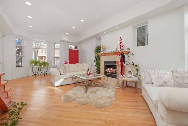 living room with light wood finished floors, recessed lighting, and a premium fireplace