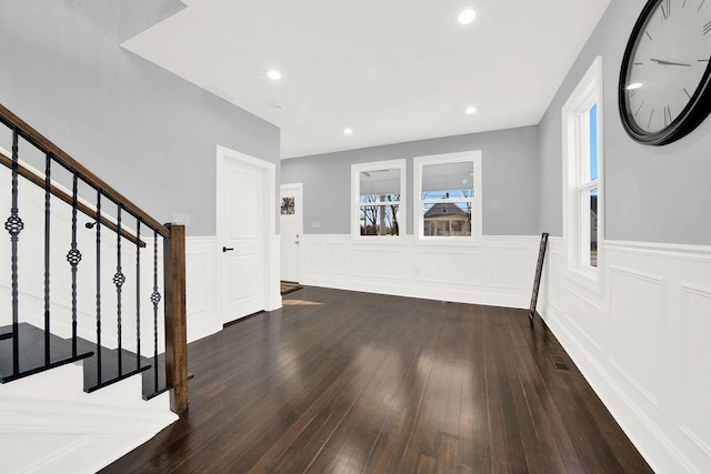 foyer featuring recessed lighting, wainscoting, hardwood / wood-style floors, and stairs