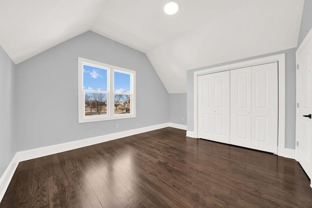 bonus room featuring lofted ceiling, baseboards, and dark wood-style flooring