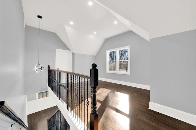 interior space featuring an upstairs landing, baseboards, lofted ceiling, and wood finished floors