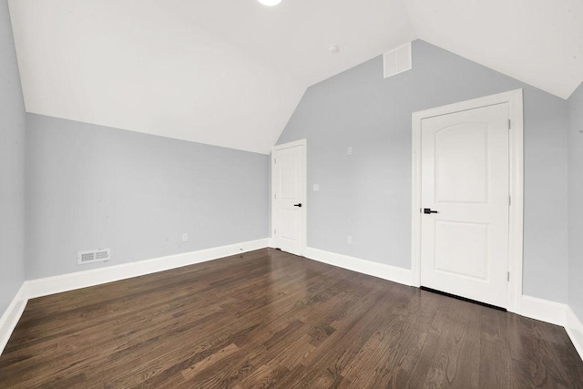 bonus room with visible vents, baseboards, dark wood-type flooring, and vaulted ceiling