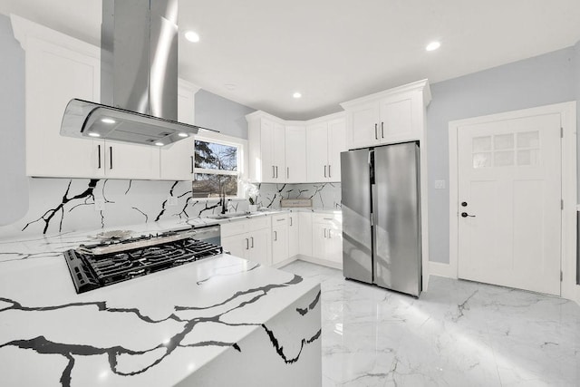 kitchen featuring marble finish floor, freestanding refrigerator, island range hood, decorative backsplash, and light stone countertops