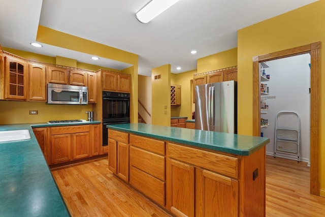3048 Brampton Ln, Dyer, IN 46311 - kitchen with stainless steel appliances, light wood finished floors, glass insert cabinets, a kitchen island, and recessed lighting