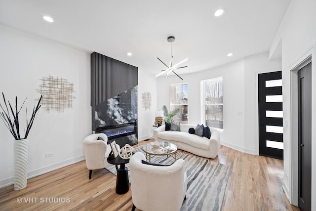 living area with light wood-style flooring, baseboards, and recessed lighting