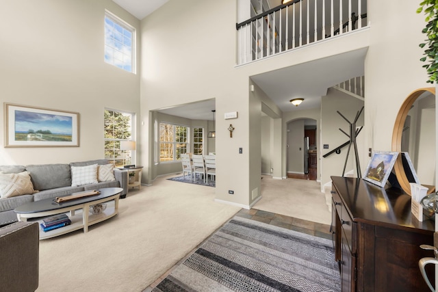 carpeted foyer entrance with baseboards and arched walkways