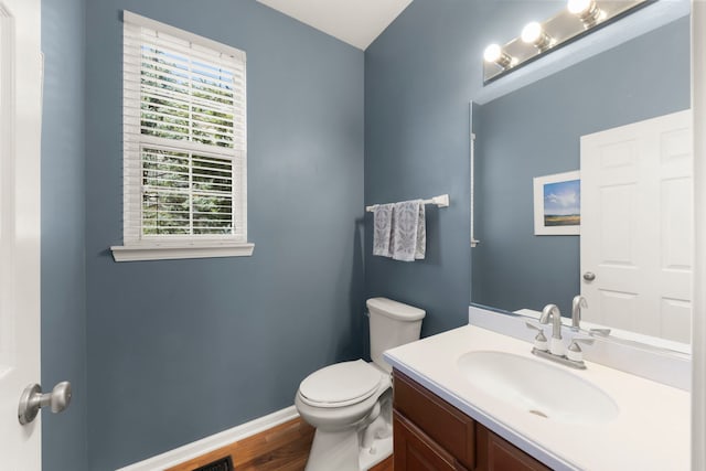 bathroom featuring baseboards, toilet, vanity, and wood finished floors