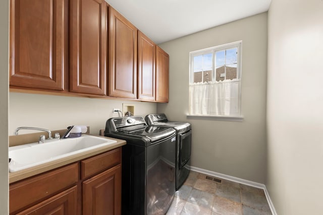 laundry area featuring a sink, baseboards, visible vents, washer and dryer, and cabinet space