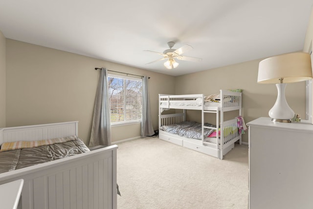 bedroom featuring a ceiling fan, light carpet, and baseboards