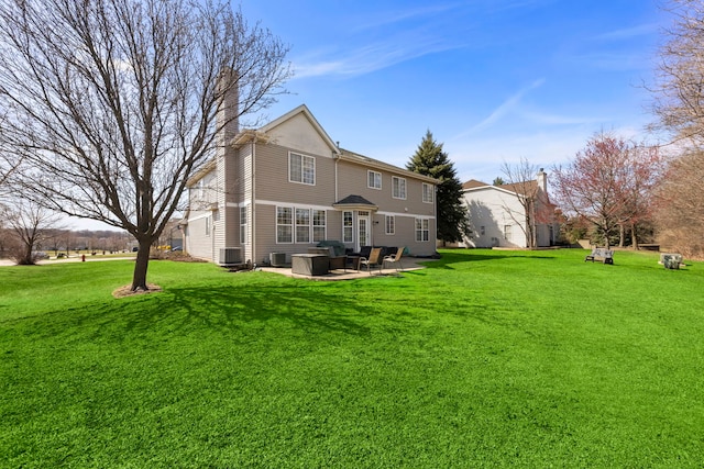 rear view of property featuring a chimney, cooling unit, a yard, and a patio area