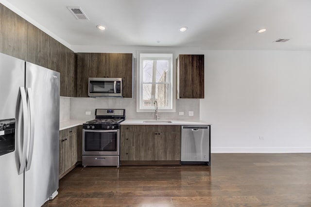 kitchen featuring visible vents, stainless steel appliances, light countertops, and a sink
