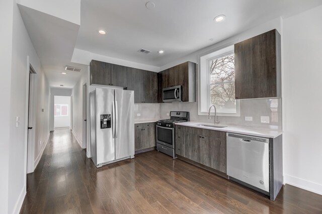kitchen with visible vents, light countertops, stainless steel appliances, modern cabinets, and a sink