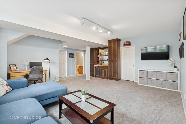 living area with track lighting, carpet, wine cooler, and baseboards
