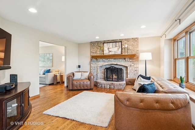 living area featuring wood finished floors, a fireplace, baseboards, and recessed lighting