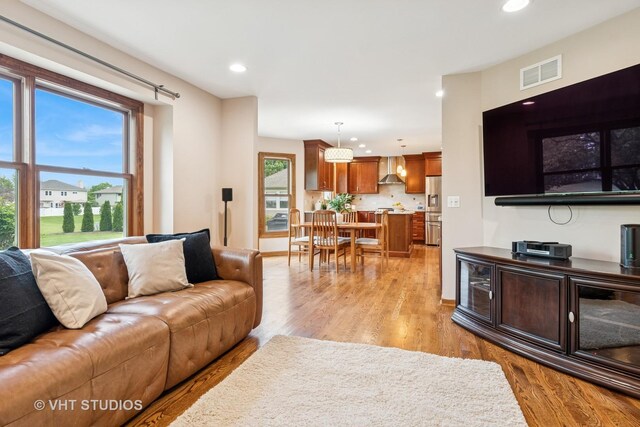 living area featuring recessed lighting, light wood finished floors, and baseboards
