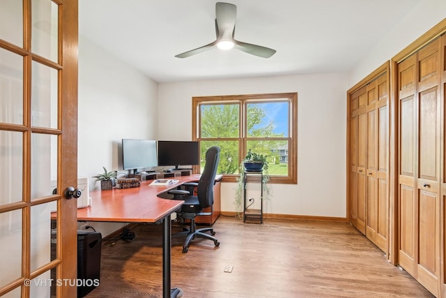 office space featuring light wood-style floors, ceiling fan, baseboards, and french doors