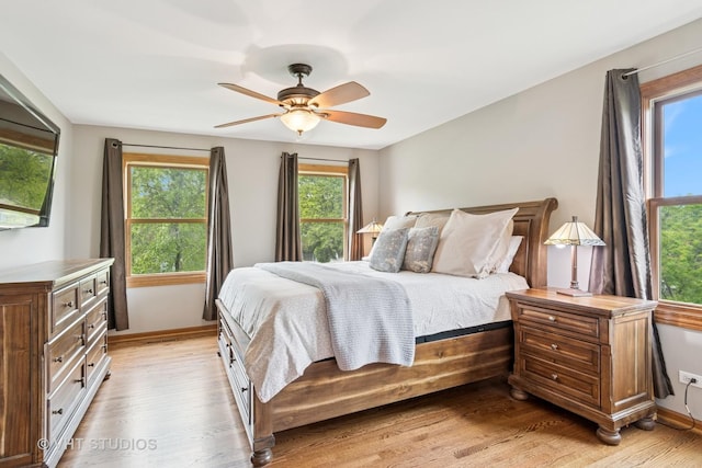 bedroom featuring light wood-type flooring, baseboards, and ceiling fan