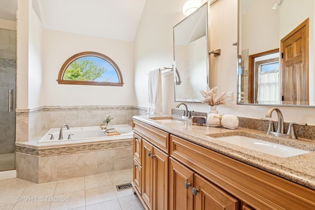 bathroom featuring a bath, tile patterned flooring, a stall shower, vaulted ceiling, and double vanity