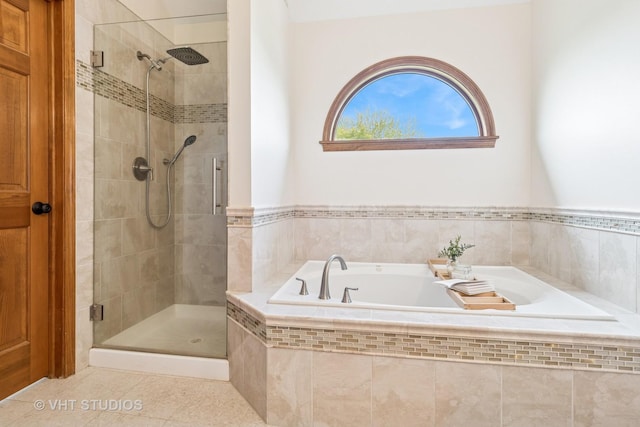 bathroom with a shower stall, a bath, and tile patterned flooring